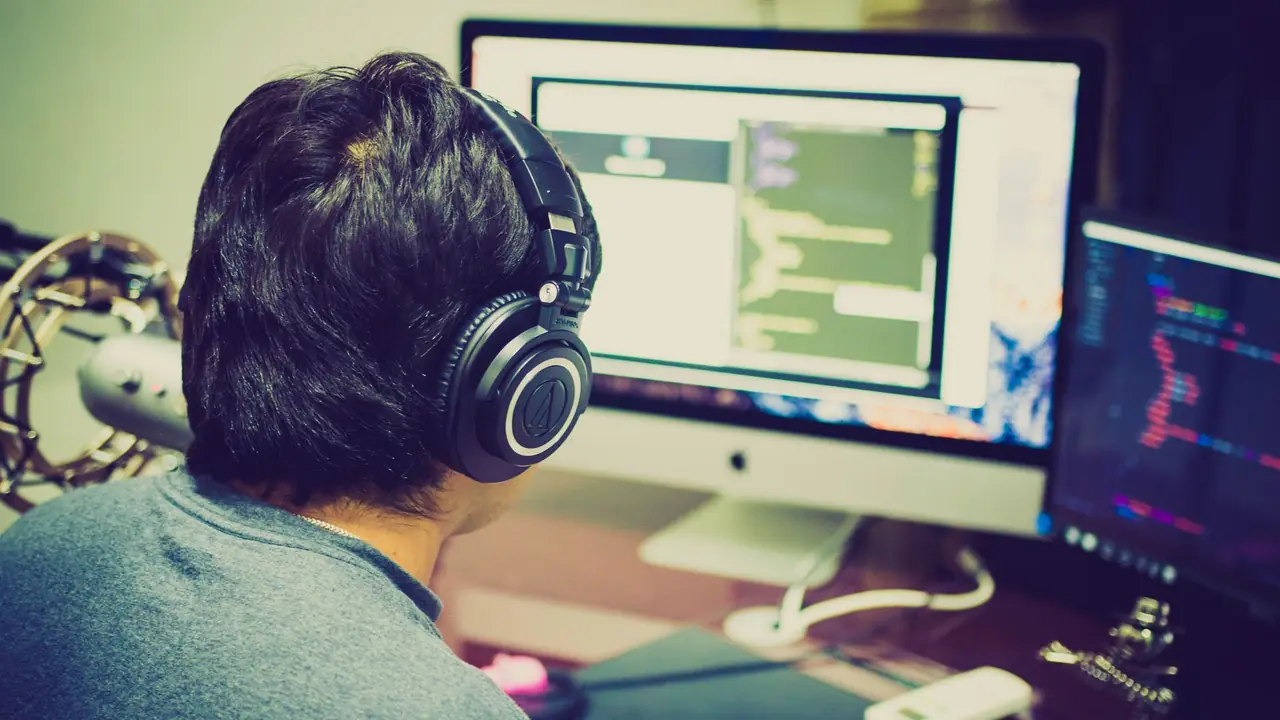 Développeur écrivant du code sur plusieurs écrans