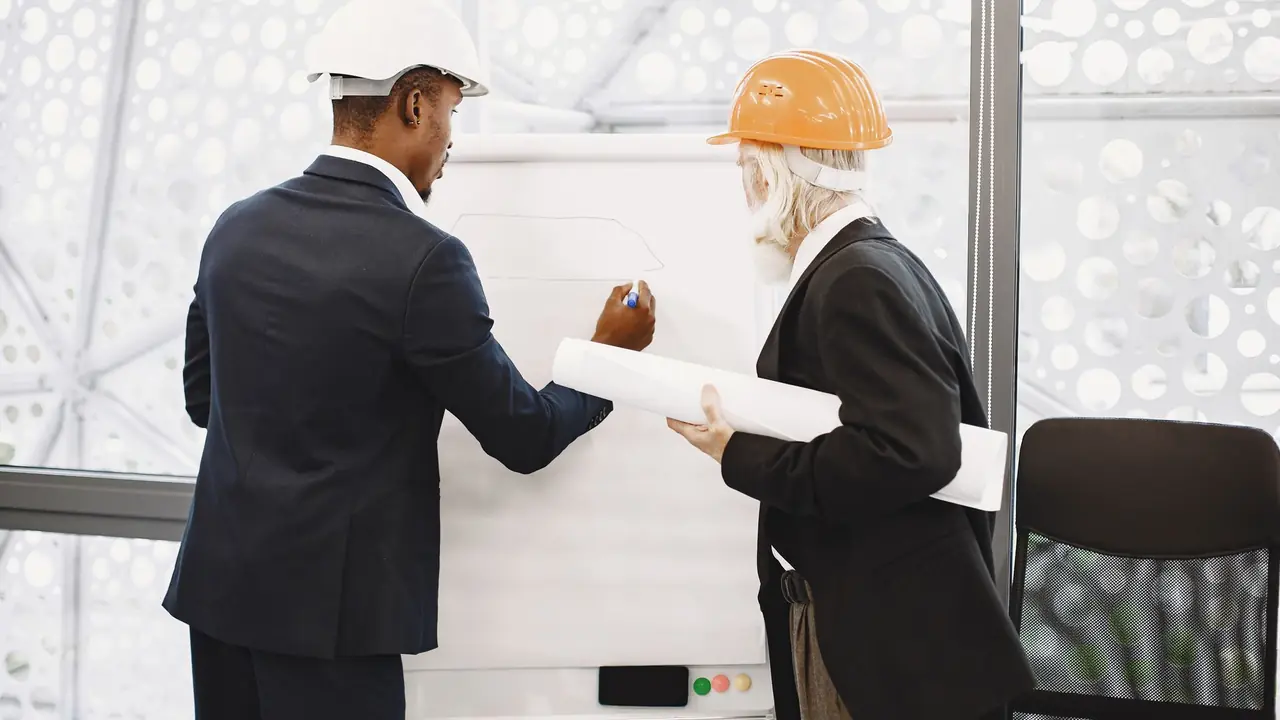 Équipe technique en discussion devant un tableau